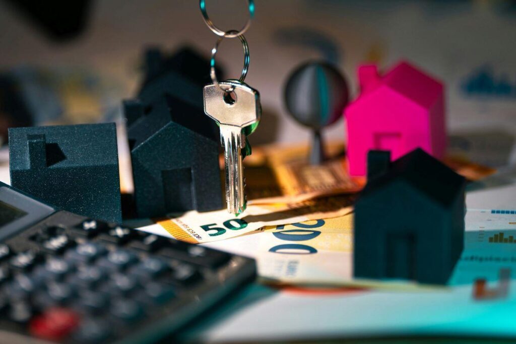 A key  and black plastic houses with paper money under